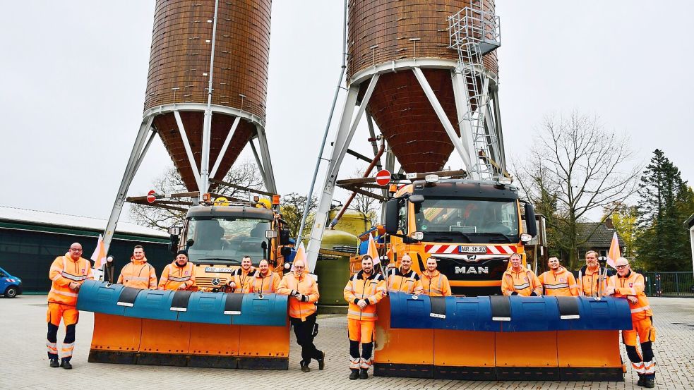 Sie sorgen auch im Winter für sichere Straßen: Ein Teil der insgesamt 25 Mitarbeitenden der Straßenmeisterei in Aurich. Hinter ihnen befinden sich zwei Silos, in denen das Streusalz gelagert wird. Foto: Niedersächsische Landesbehörde für Straßenbau und Verkehr