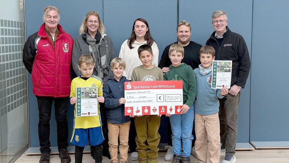Die Eichenwallschule in Leer hat 200 Euro beim Multi-Cup gewonnen. Bei der Übergabe des symbolischen Schecks waren dabei (von links): Reiner Voskamp (SV Frisia Loga), Schulleiterin Xenia Bruns, Lehrerin Anna Duin, Jan-Niklas Eickels (Trainer des Schulteams) und Matthias Brahms sowie (vorne) die Schüler Benjamin, Tammo, Alexandre, Theo und Mateo. Foto: privat