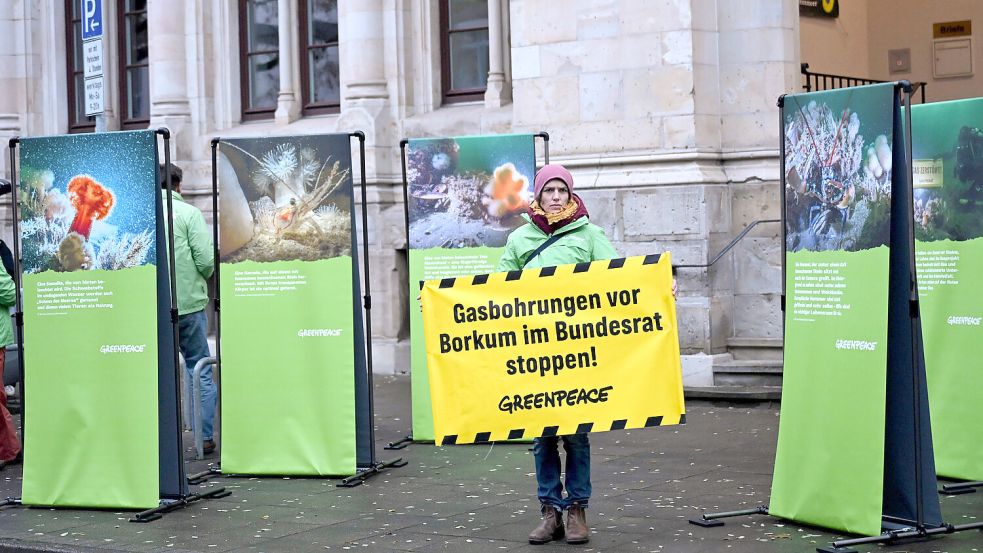 Der Widerstand ebbt nicht ab: Ein Aktivistin von Greenpeace protestiert am Montag, 17. November, vor dem niedersächsischen Umweltministerium gegen Gasbohrungen vor der Insel Borkum. Der niederländische Energiekonzern One-Dyas will dort in unmittelbarer Nähe zum Unesco-Weltnaturerbe nach fossilem Gas suchen. Foto: Shireen Broszies/dpa