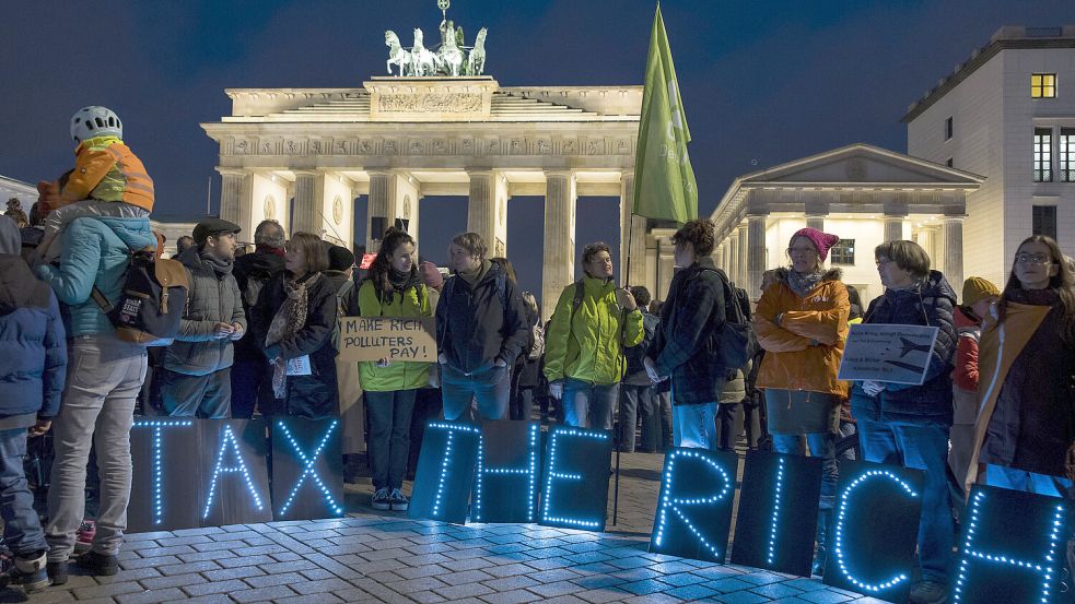 „Besteuert die Reichen“: Protest vor dem Brandenburger Tor in Berlin. Foto: IMAGO/Ben Kriemann
