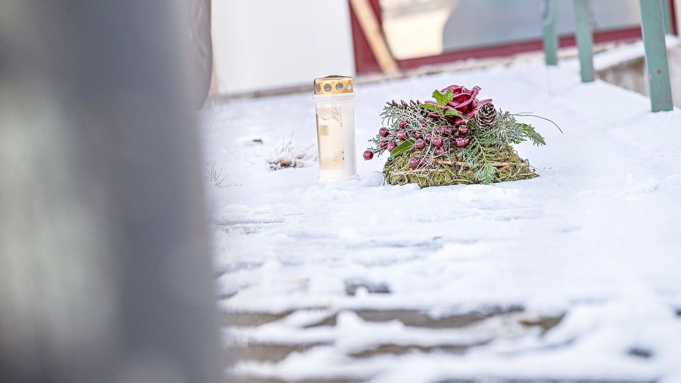 Vor dem Firmengebäude, in dem die Leichen der beiden Söhne gefunden wurden, liegen eine Kerze und ein Kranz. Foto: Jason Tschepljakow/dpa