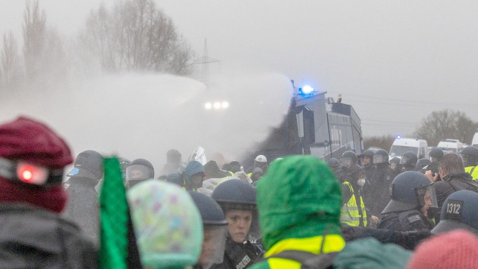 Die Polizei setzt Wasserwerfer gegen Demonstranten ein, die die B429 nahe der Lahnbrücke blockieren. Foto: Lando Hass/dpa