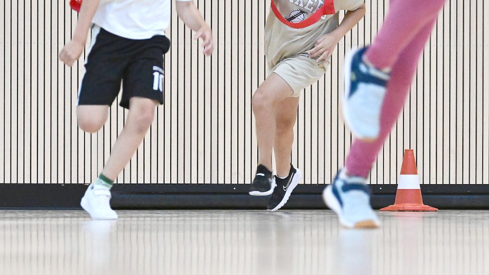 Kinder laufen durch eine Turnhalle. Foto: Bernd Weißbrod/dpa