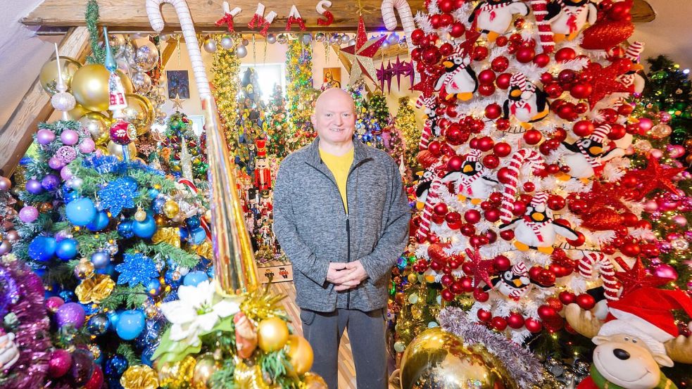 Thomas Jeromin steht inmitten von Weihnachtsbäumen in seinem Haus im Landkreis Schaumburg. Foto: Julian Stratenschulte/dpa