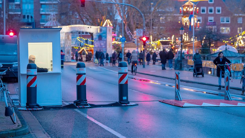 An einigen gesperrten Zufahrtswegen zum Emder Weihnachtsmarkt sitzt Sicherheitspersonal, damit Rampen für den Busverkehr und Rettungseinsätze abgesenkt werden können. Foto: Klaus Ortgies