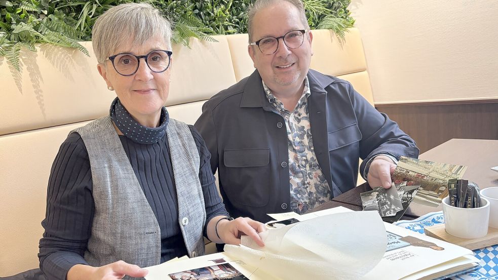 Magrit de Wall und Andree Winkler blätterten in einem Album mit Bildern aus der Geschichte des Kaufhauses de Wall. Foto: Marion Janßen