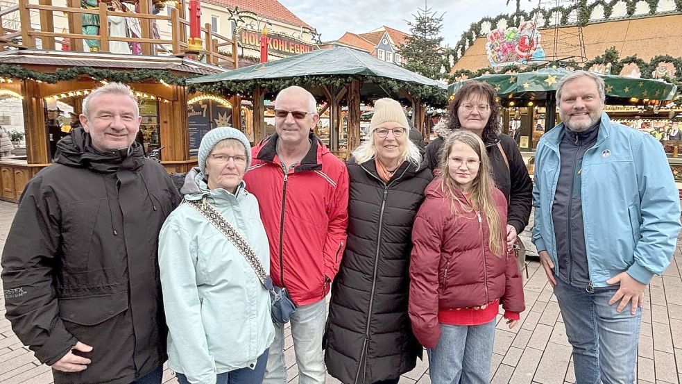 Marco Bordasch (von Links), Adele und Siegfried Göken, Helga Paulokat, die neunjährige Gewinnerin Zoey Beutel, Monika Bijl und Udo Hippen stehen vor der Goldenen 7 auf dem Auricher Weihnachtszauber. Foto: Lasse Paulsen