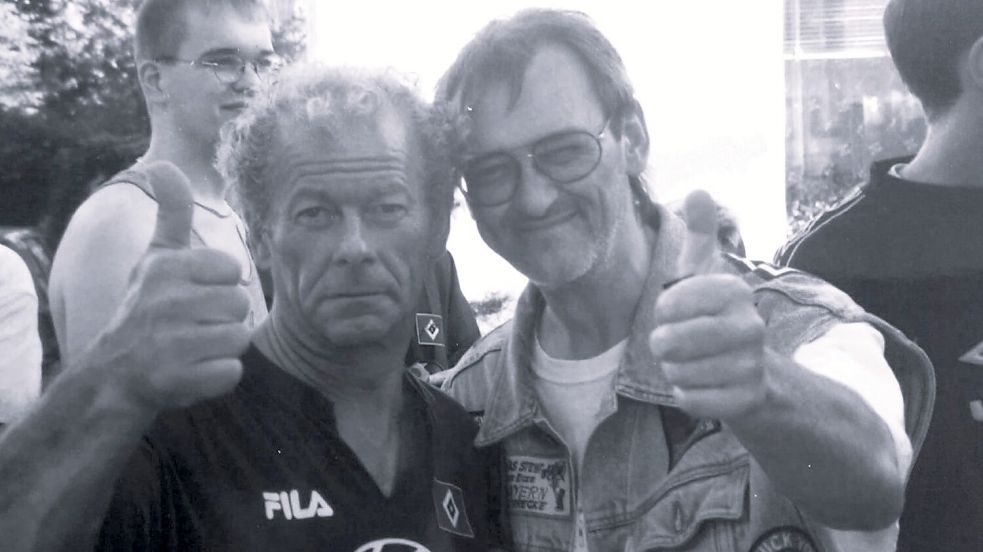 Doppelter Kult: Das Lieblingsfoto von Jürgen Hesse (rechts) zeigt ihn im Stadion beim Freundschaftsspiel des HSV in Aurich mit dem HSV-Vereinsidol und Kult-Masseur Hermann Rieger. Das Foto hing seit den 90er Jahren im Herrensalon seines Friseurgeschäfts – gleich neben den Wimpeln mit dem Tabellenstand. Foto: Privat