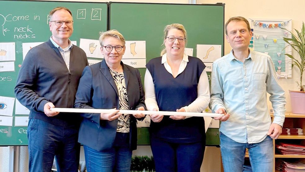 Aurichs Stadtbaurat Mirko Wento (von links), Dr. Edith Ulferts (Fachbereich Bildung und Soziales), Elke Seehusen (Fachdienst Hochbau) und Schulleiter Kai Münzel zeigen eine Leuchtstoffröhren, die ausgedient haben. Foto: privat