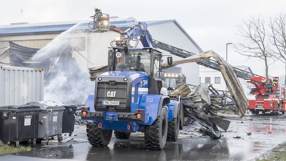 Während ein Feuerwehrmann von der Drehleiter aus das Feuer löschte, entfernte der Fahrer eines THW-Radladers Metallteile. Foto: THW