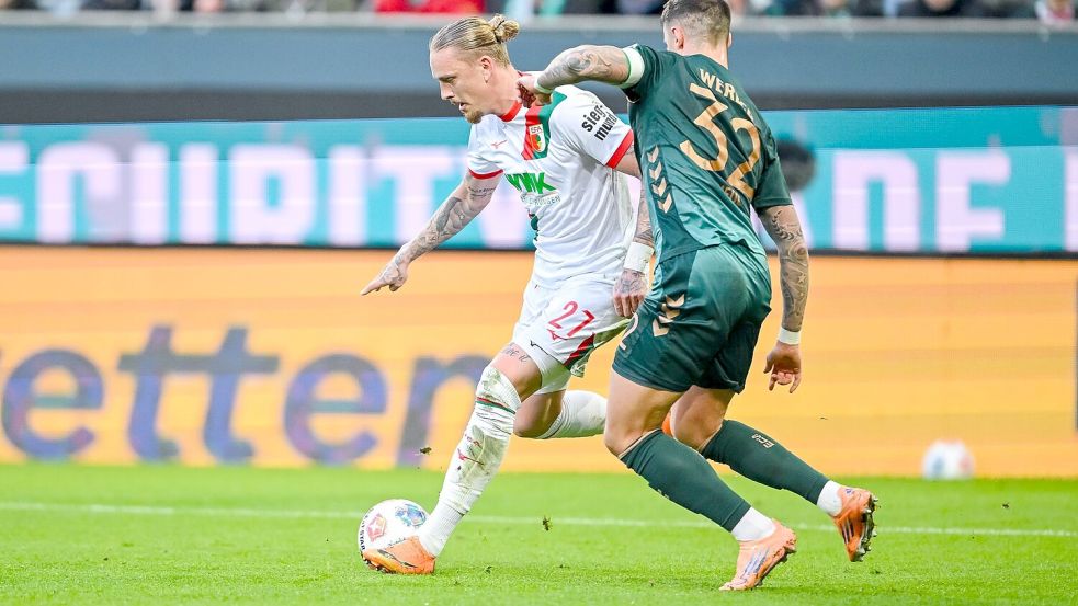 Augsburgs Marius Wolf (l) im Zweikampf mit Werder-Verteidiger Marco Friedl. Foto: Harry Langer