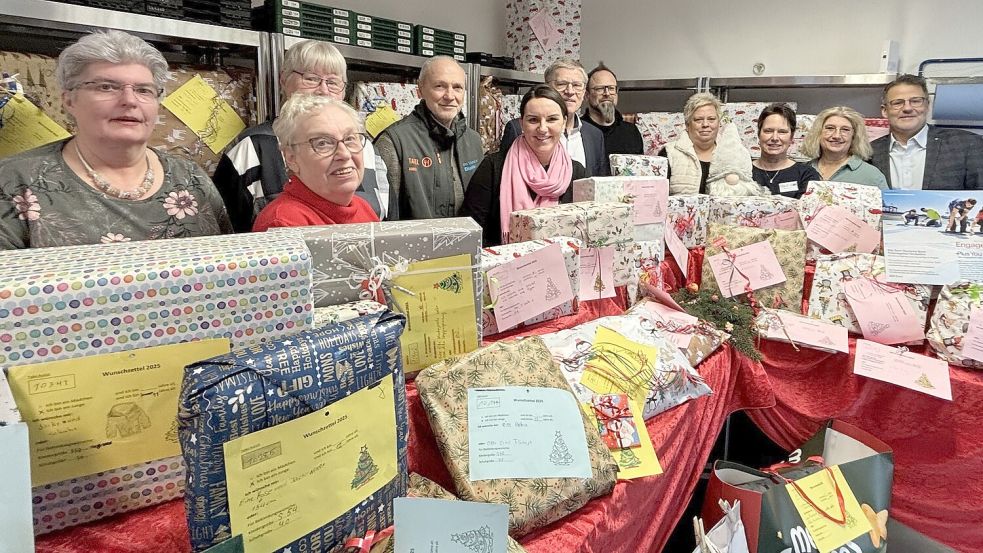 Die Vertreter der Tafeln Aurich und Großefehn, von Rudnick, Baustoffunion, der deutschen Bank und Aurichs Bürgermeister Horst Feddermann (sechster von links) zwischen den 260 Geschenken. Es fehlt der Großefehntjer Gemeindebürgermeister Erwin Adams. Foto: Lasse Paulsen