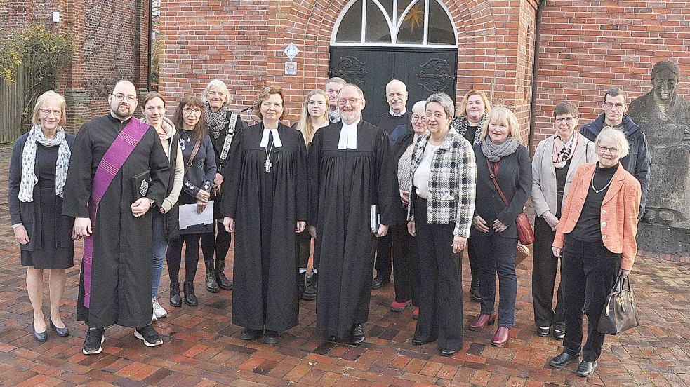 Regionalbischöfin Sabine Schiemeyer (6. von links) war nach Bingum gekommen, um Armin Siegmund (rechts daneben) und dessen Ehefrau Bettina Siegmund (in karierterJacke) zu gratulieren. Mit ihnen freuen sich die Kirchenräte der drei Gemeinden und ihre Gäste. Foto: Bodo Wolters
