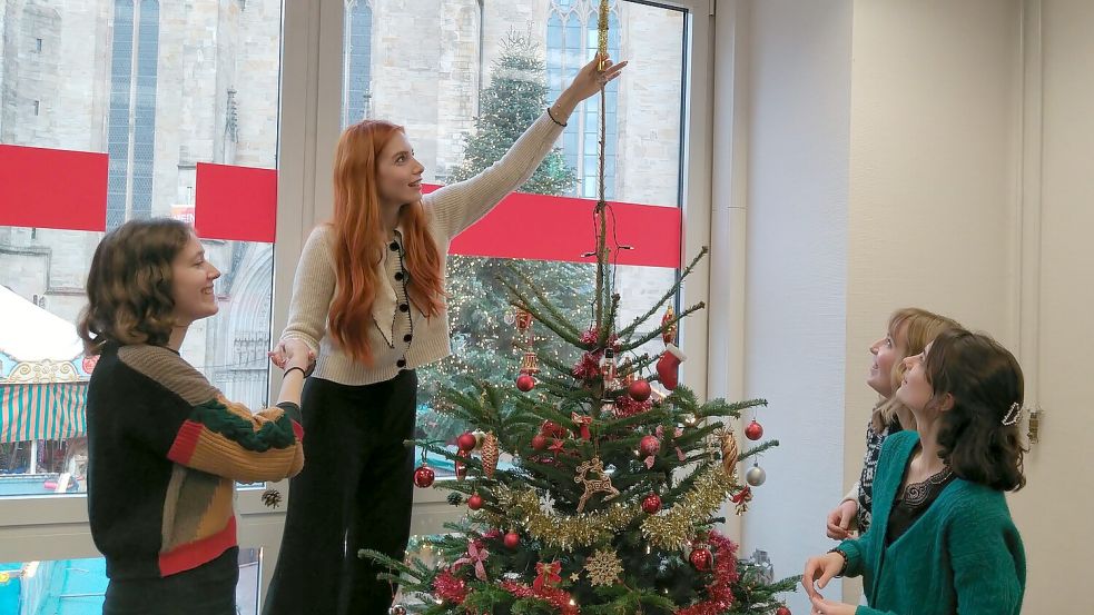 Frauenpower: Osnabrücks Städtebotschafterinnen beim Schmücken des Weihnachtsbaums in der Stadtbibliothek. Foto: Julian Blome