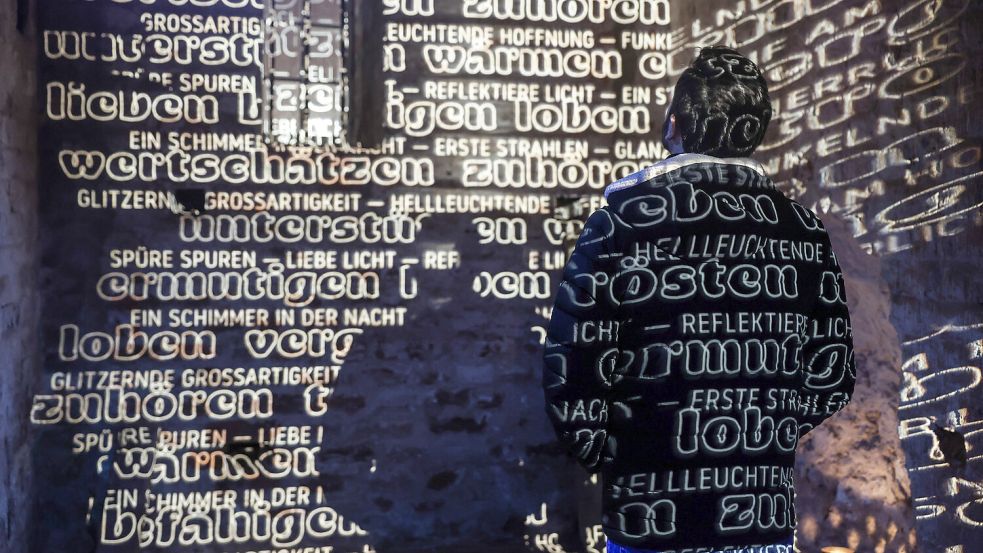 Ein Mann steht in den „Lichtreflexen“ im Auricher Lambertiturm. Foto: Claus Hock