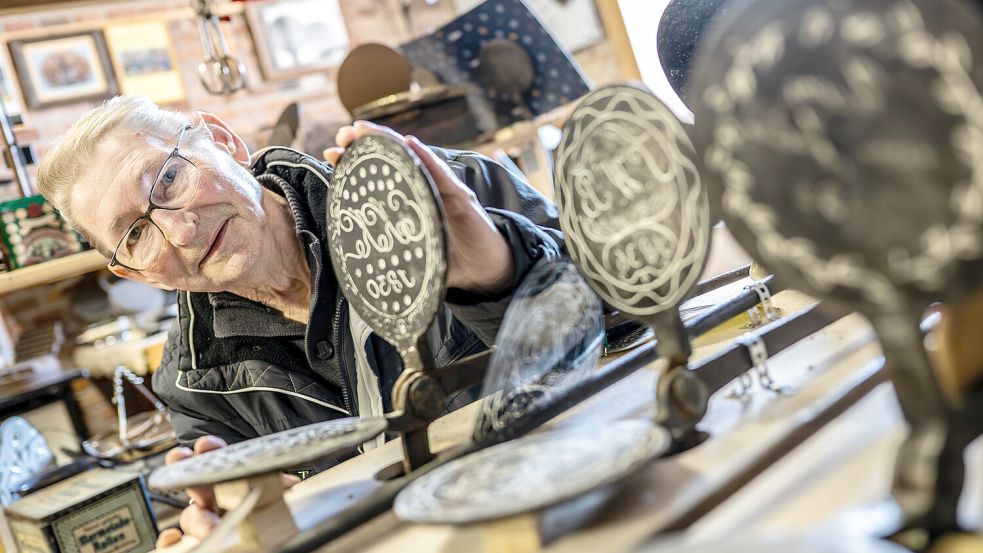 Alt und schwer sind die Neujahrseisen, die in der Mühle Neermoor ausgestellt werden. Heinz Seemann zeigt ein Exemplar von 1830. Foto: Klaus Ortgies
