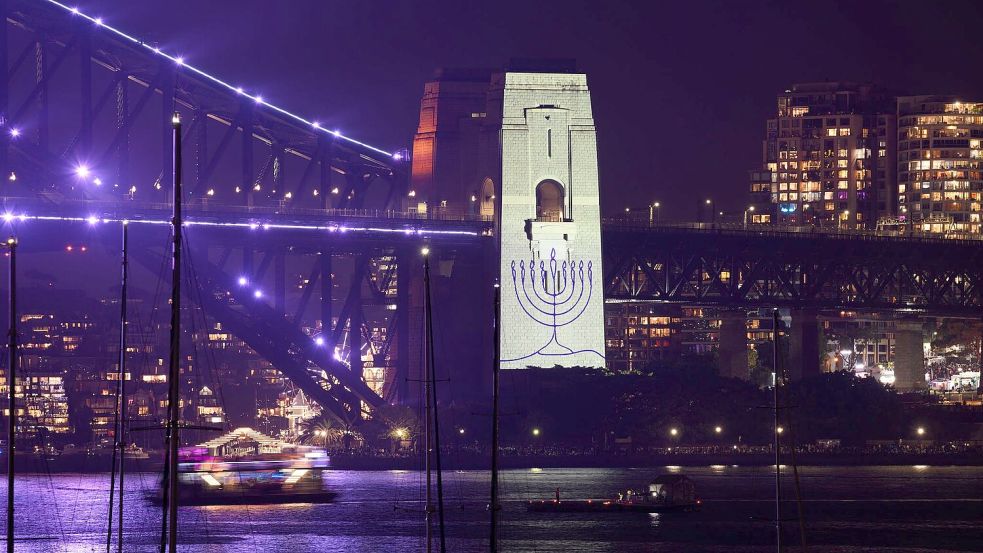Während einer Schweigeminute wurde eine Menora auf einen Pfeiler der Sydney Harbour Bridge projiziert. Foto: Dan Himbrechts