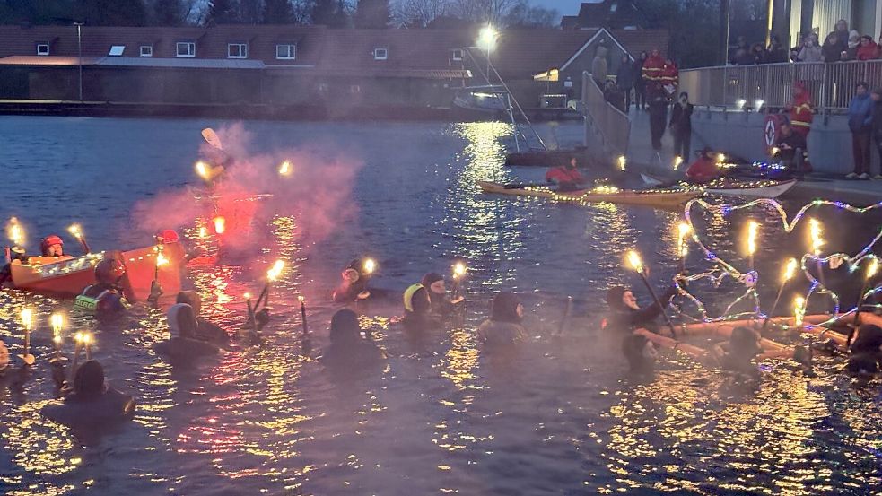 Mit Fackeln und Flößen schwammen die Teilnehmer durch das Hafenbecken. Foto: Rebecca Kresse