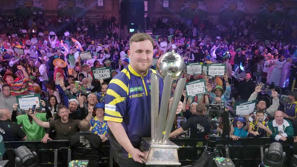 Littler präsentiert zum zweiten Mal die WM-Trophäe. Foto: Dave Shopland/AP/dpa