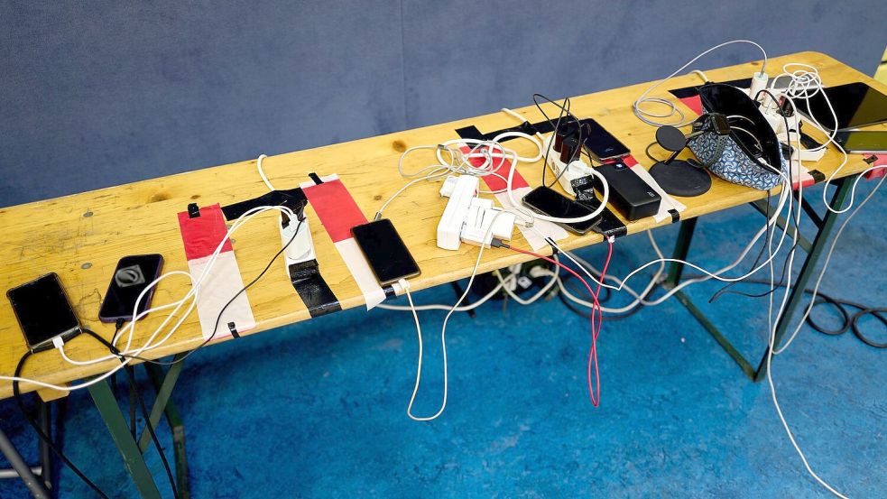 Viele Menschen nutzen die Möglichkeit, ihre Handys an Anlaufstellen aufzuladen. Foto: Michael Ukas