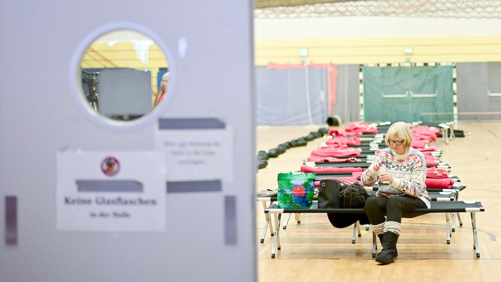 Eine Frau wartet während des Stromausfalls im Südwesten Berlins in einer Notunterkunft. Foto: dpa/Sebastian Gollnow