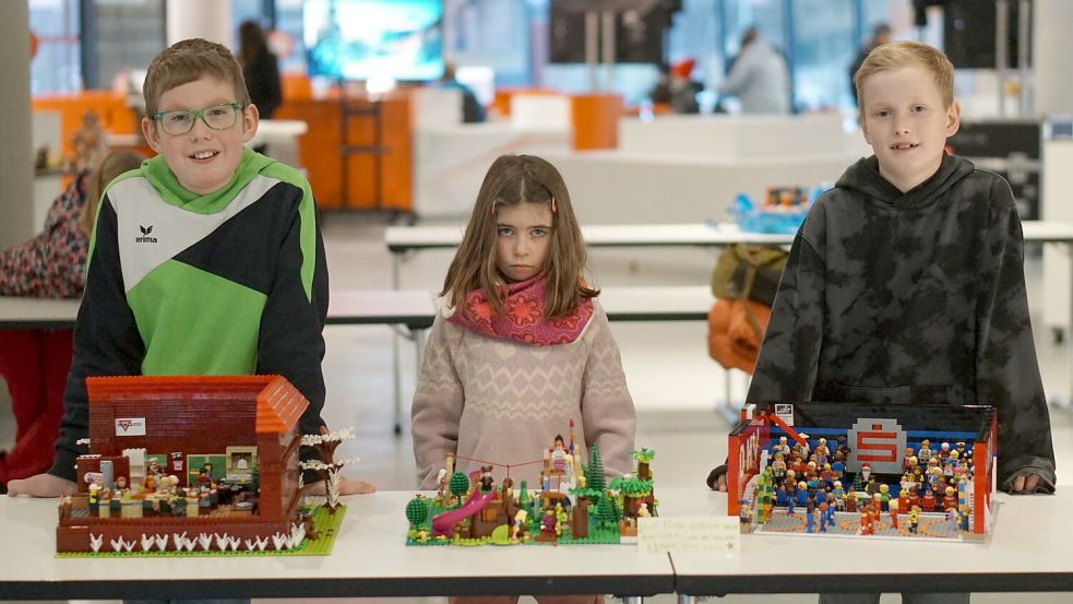 Die Gewinner des 26. Auricher Lego Wettbewerbes im EEZ: Jonas Groeneveld (von links) siegte mit dem CVJM-Frühstücksraum, Anna-Lena van der Houwen belegte mit ihrer Darstellung des Spielplatzes im Egelser Wald den zweiten Platz und Dan Mackensen den dritten Platz mit einem OHV-Spiel in der Sparkassen-Arena. Foto: Jurij Babanin
