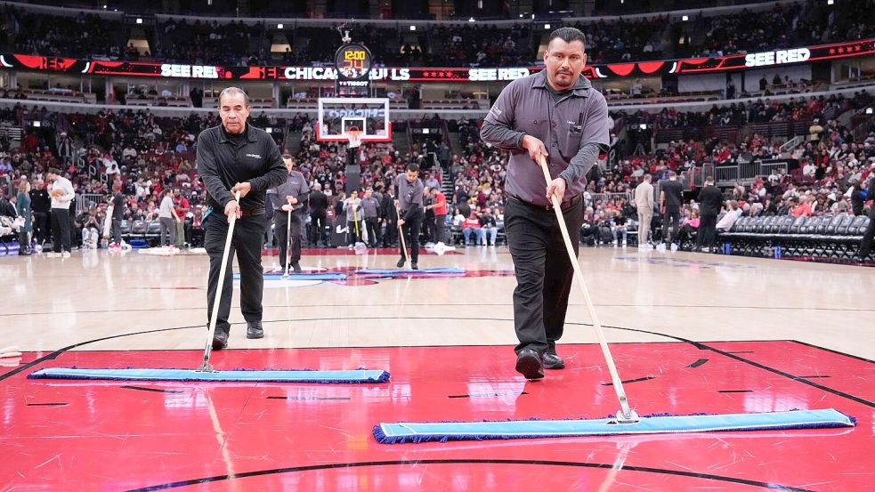 Helfer versuchen, das Spielfeld in Chicago zu trocknen. Foto: Nam Y. Huh/AP/dpa