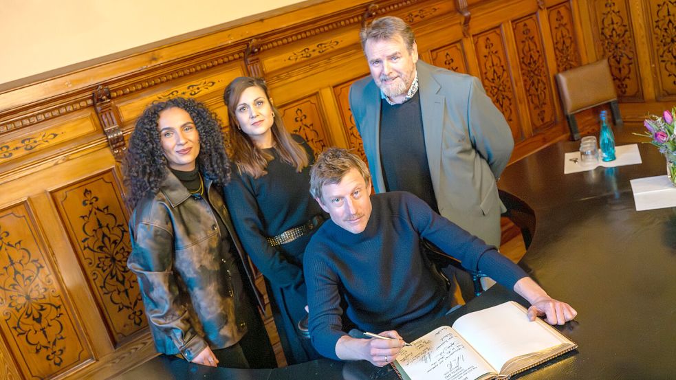 Die Schauspielerinnen und Schauspieler der „Friesland“-Reihe Veronique Coubard (stehend, von links), Sophie Dal und Felix Vörtler sowie Maxim Mehmet (vorne) haben sich im Goldenen Buch verewigt. Foto: Klaus Ortgies