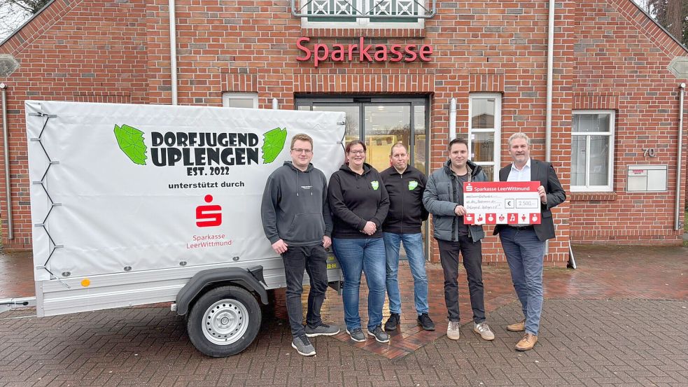 Kai Gerdes (von links), Stephanie Saathoff und Sascha Hinrichts vom Förderverein der Dorfjugend Uplengen, Sören Brunken (Vorstand der Dorfjugend) sowie Sparkassen-Leiter Andreas Faß als Sponsor freuen sich über die gelungene Anschaffung des Anhängers. Foto: privat
