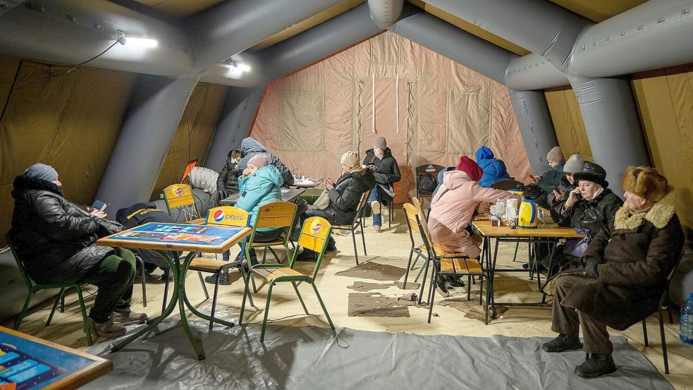In Zelten können Menschen in Kiew sich aufwärmen, etwas Heißes trinken und ihre Geräte aufladen. Foto: Danyil Bashakov/AP/dpa