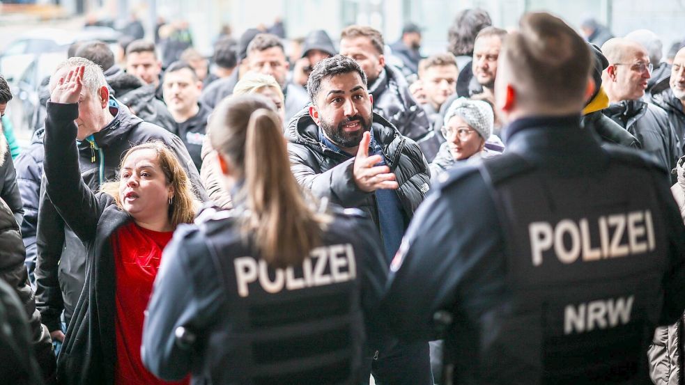 Aufgebrachte Kunden diskutieren vor der Sparkassenfiliale mit Polizeibeamten (Archivfoto) Foto: Christoph Reichwein