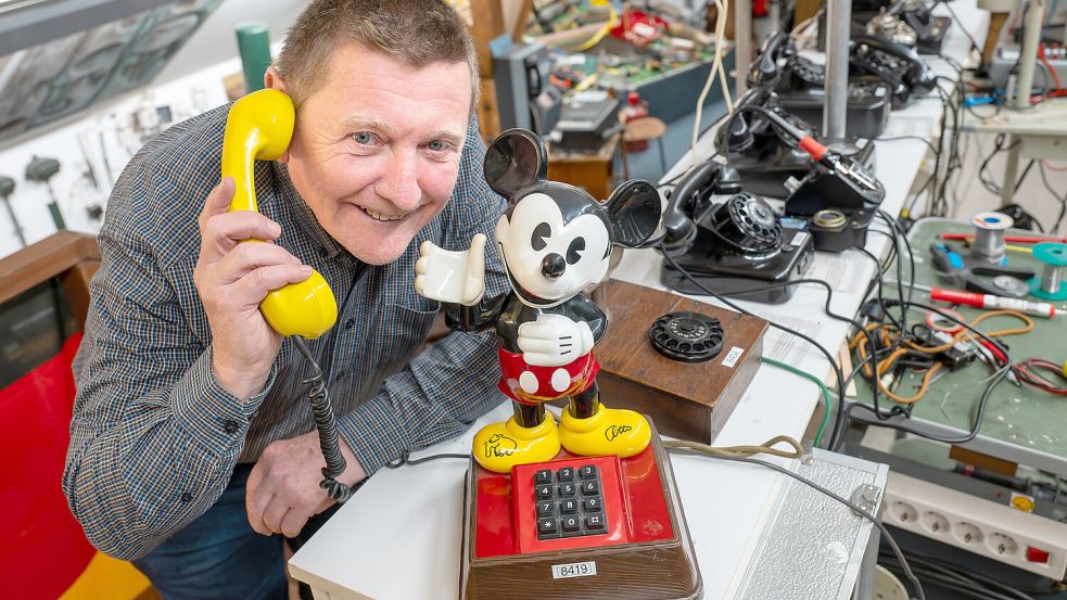 Walter Brückmann, Vorsitzender des Museumsvereins, präsentiert einen Publikumsliebling: das Mickey-Mouse-Telefon. Foto: Klaus Ortgies