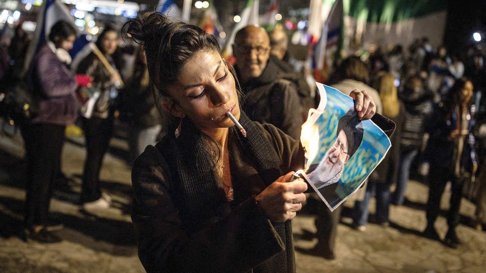 Eine Frau in Holon (Israel) verbrennt ein Portrait des Obersten Führer des Iran, Ayatollah Ali Khamenei während einer Demonstration in Solidarität mit den iranischen Protestierenden am vergangenen Mittwoch. Foto: afp / John Wessels