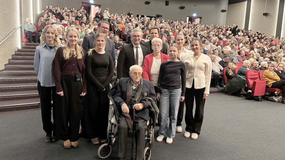 Volles Festspielhaus für Albrecht Weinberg. Rund um den 100-Jährigen haben sich für das Foto die Moderatorinnen und Vorleserinnen des Abends aufgestellt. Ebenso wie Oberbürgermeister Tim Kruithoff (hintere Reihe, Zweiter von links), Max-Windmüller-Gesellschaft-Vorsitzender Kai Gembler (rechts daneben), Autor Nicholas Büchse (rechts daneben) und Weinbergs Begleitung Gerda Dänekas (rote Jacke). Foto: Mona Hanssen