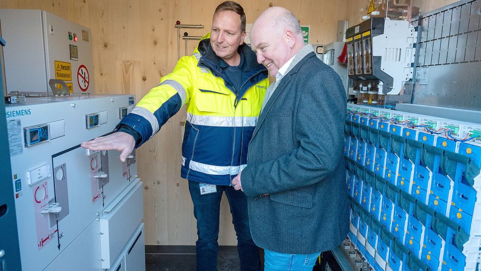 Bürgermeister Claus-Peter Horst (rechts) wirft einen Blick in die Ortsnetzstation, die das geplante Quartier in Leer mitversorgen wird. Foto: Klaus Ortgies