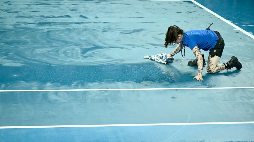 Ballkinder versuchten mit Handtüchern, die Plätze im Melbourne Park wieder zu trocknen. Foto: Joel Carrett