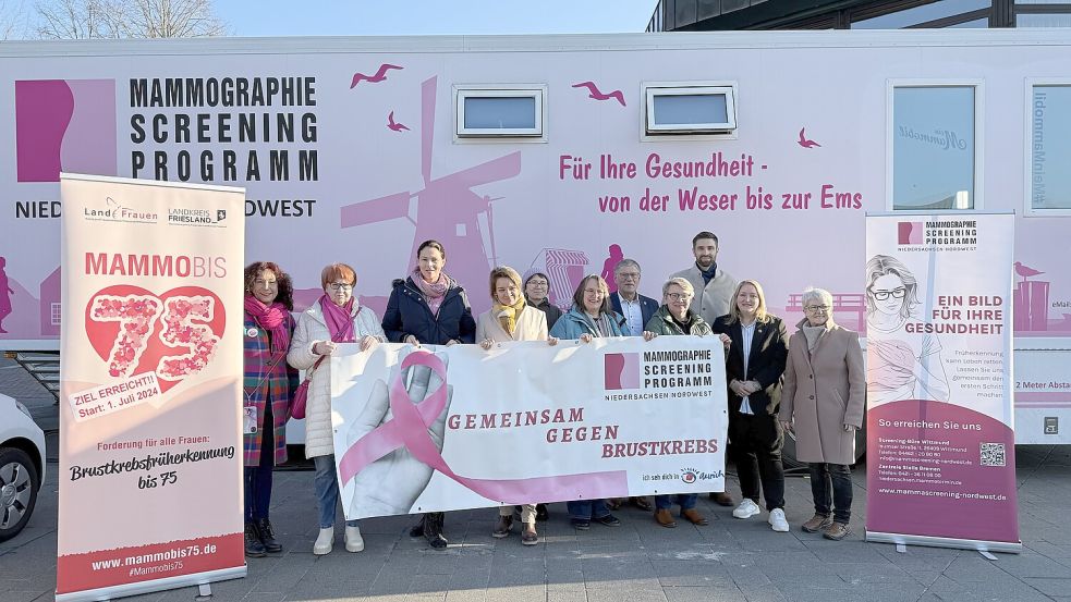 Sie machen Werbung für die Brustkrebsfrüherkennung: Bürgermeister Horst Feddermann (5. von rechts), die Gleichstellungsbeauftragte Anna Eggers (5. von links) und Auricher Ratsfrauen mit dem programmverantwortlichen Arzt Dr. Moritz Kaup mit seiner Mitarbeiterin Birgitt Kampen-Neumann (links) vom Mammographie Screening Niedersachsen-Nordwest am Mammobil. Foto: Stadt Aurich