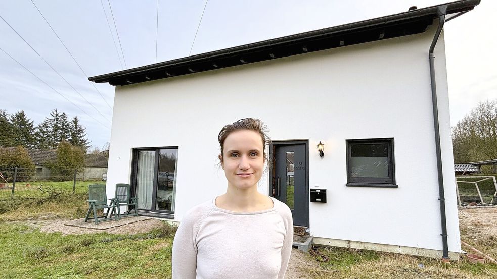 Annika Eggers vor dem Haus ihrer Familie am Spechtweg in Mullberg. Dort hat sie mit ihrem Mann 2024 direkt unter der Hochspannungsleitung gebaut. Foto: Nicole Böning