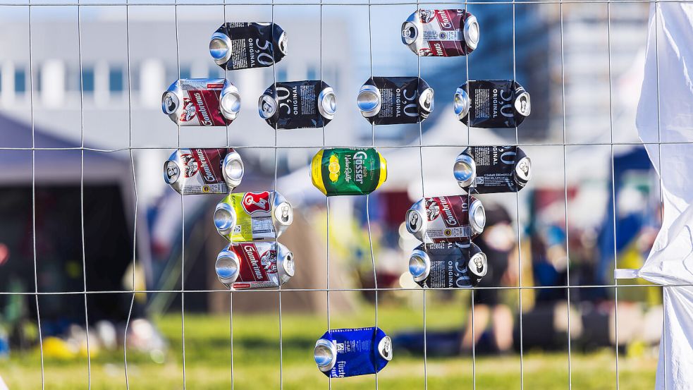 Ein stilisiertes Herz aus Bierdosen hängt am Zaun eines Zeltplatzes auf dem Southside Festival. Foto: DPA