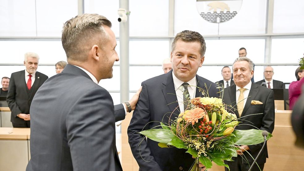 Sven Schulze bekommt Glückwünsche und einen Blumenstrauß vom AfD-Spitzenkandidaten Ulrich Siegmund. Foto: Hendrik Schmidt