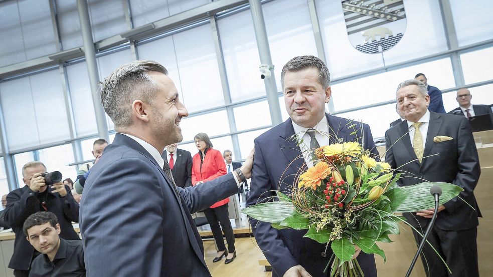 Konkurrieren um die Wähler: Der Vorsitzende der AfD-Landtagsfraktion, Ulrich Siegmund, gratuliert Sven Schulze zur Ministerpräsidentenwahl. Foto: AFP/Ronny Hartmann