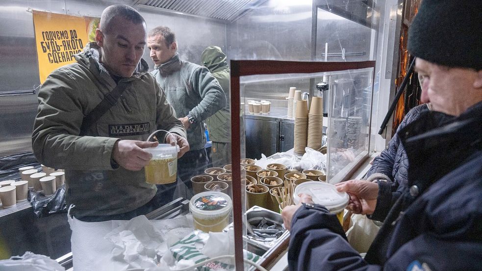 In Kiew geben die Streitkräfte warme Mahlzeiten für Menschen aus, die in ihren Häusern keinen Strom mehr haben. Foto: Danylo Antoniuk/AP/dpa