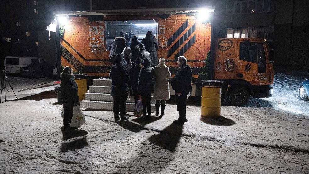 In Kiew stehen Bürger für warme Mahlzeiten Schlange, da es in vielen Häusern weder Strom noch Fernwärme gibt. Foto: Danylo Antoniuk/AP/dpa
