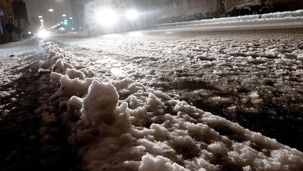 Ein Auto fährt über eine verschneite Straße in der Stadt: Aufgabe des Winterdienstes ist es, die Straßen befahrbar zu halten. Foto: Sven Hoppe/dpa