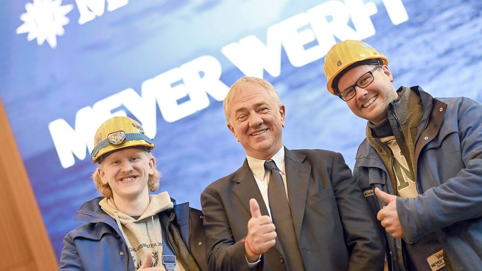 Daumen hoch für die Meyer Werft in Papenburg: Pierfrancesco Vago (Mitte), Aufsichtsratsvorsitzender von MSC Cruises, lacht mit zwei Mitarbeitern der Meyer Werft in die Kamera. Foto: Lars Penning/dpa