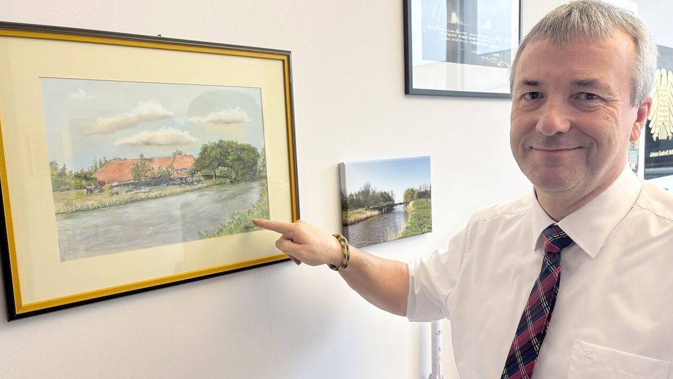 Hieran hängt sein Herz: Johann Saathoff zeigt in seinem Abgeordnetenbüro im Paul-Löbe-Haus auf ein Bild aus Ostfriesland. Dort am Ufer hat er als kleiner Junge oft gesessen und geangelt. Foto: Martin Teschke