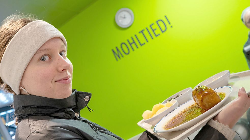 „Mohltied!“, also Mahlzeit, steht über der Kasse der Hochschul-Mensa. Unsere Praktikantin Lara Jelden hat sich fürs Foto mit Tablett aufgestellt. Foto: Klaus Ortgies
