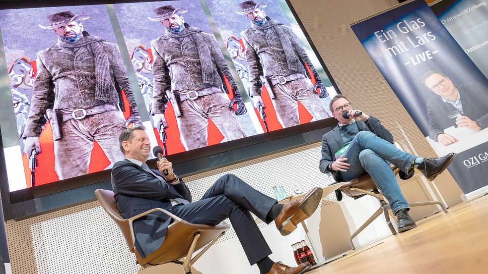 Olaf Lies (links) zu Gast bei „Ein Glas mit Lars“ von Chefredakteur Lars Reckermann. Im Hintergrund: ein gefälschtes Bild, das Olaf Lies als „Wolfskiller“ zeigt. Foto: Klaus Ortgies