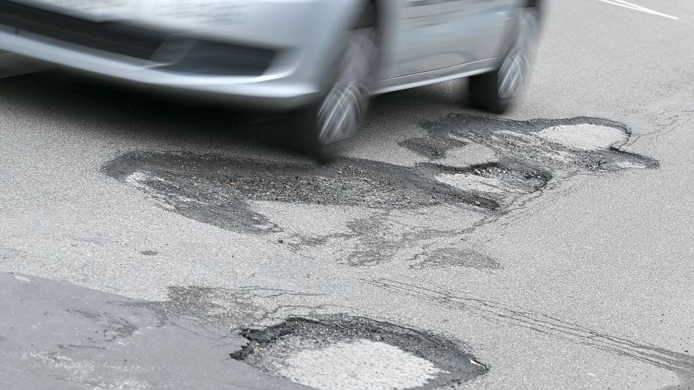 Nach den heftigen Witterungsbedingungen sind viele Straßen von Schäden gezeichnet. Foto: dpa/Arne Dedert