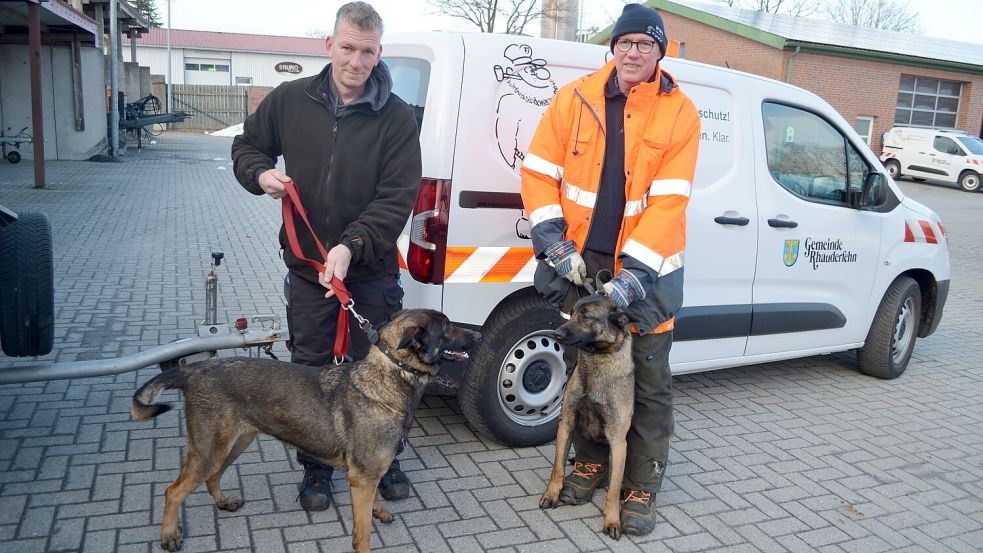 Die Rhauderfehner Bauhofmitarbeiter Andre Albers (links) und Udo Haskamp mit den beiden jungen Schäferhunden, die Passanten am Mittwochnachmittag auf der Landesstraße in Burlage entdeckt hatten. Foto: Astrid Fertig